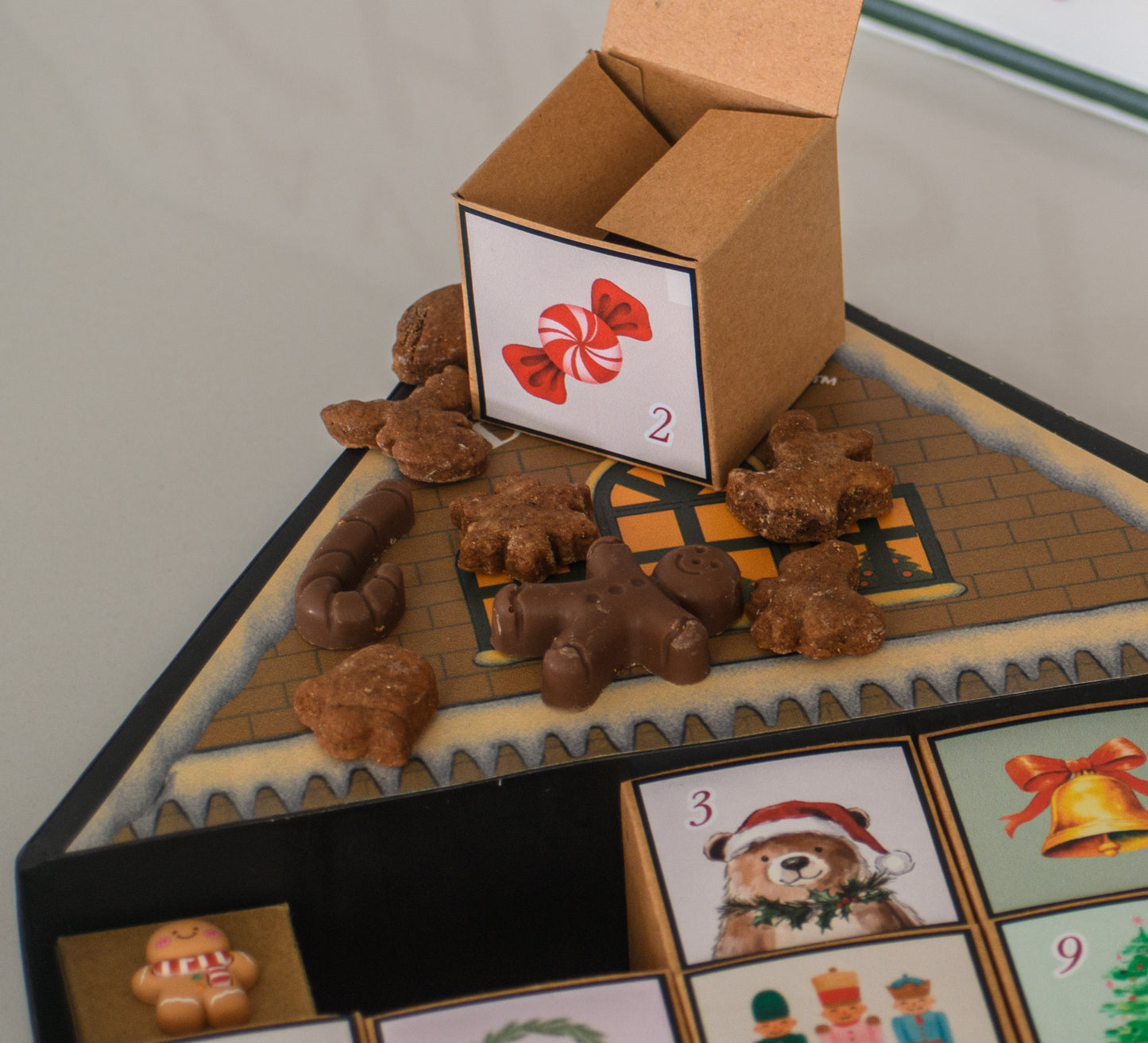 Calendario Adviento Home: Calendario de Adviento con 25 cajitas llenas de galletas y chocolates navideños, presentado en una casita metálica hecha completamente a mano. Una pieza única para vivir la magia día a día.