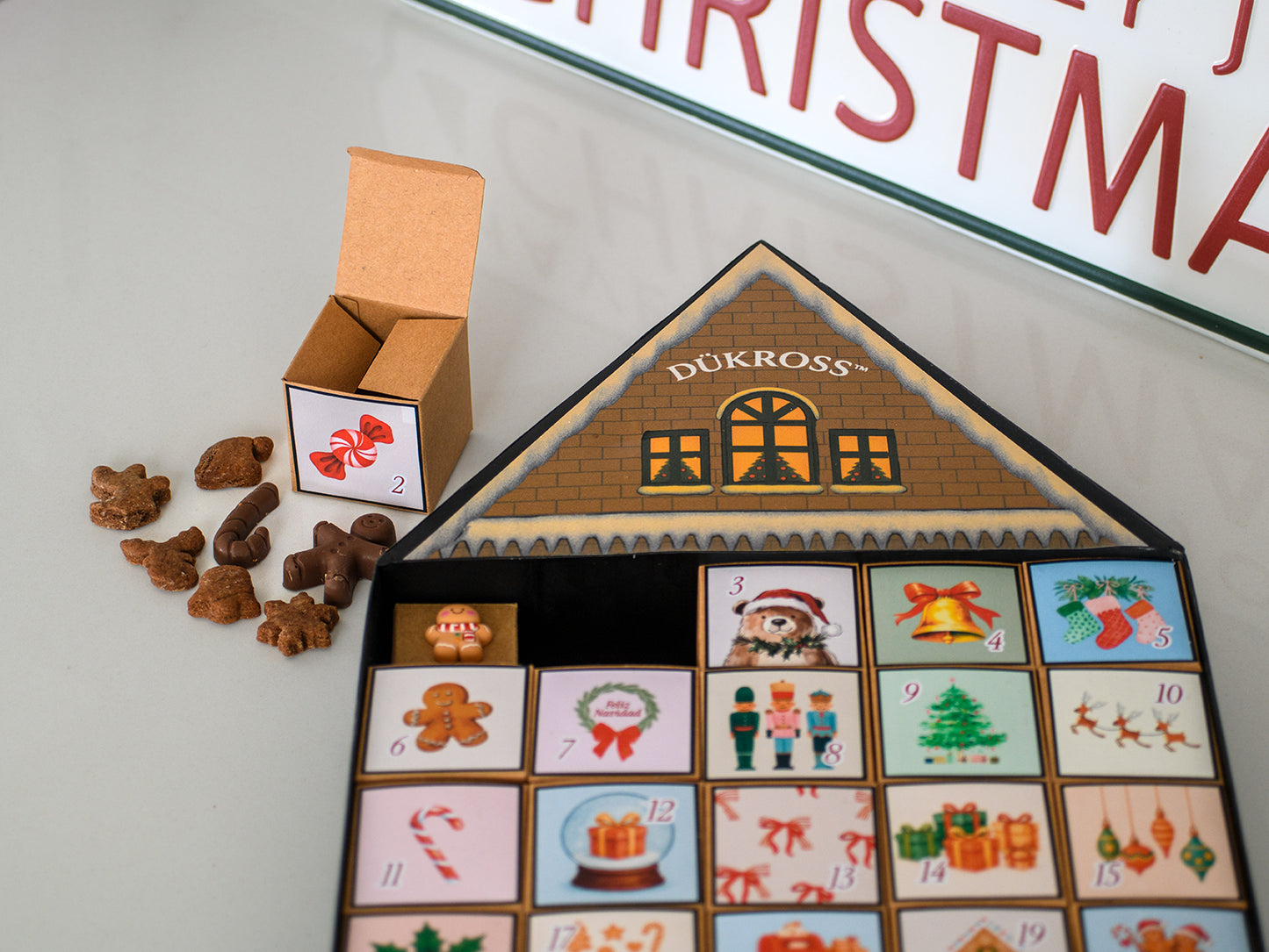 Calendario Adviento Home: Calendario de Adviento con 25 cajitas llenas de galletas y chocolates navideños, presentado en una casita metálica hecha completamente a mano. Una pieza única para vivir la magia día a día.