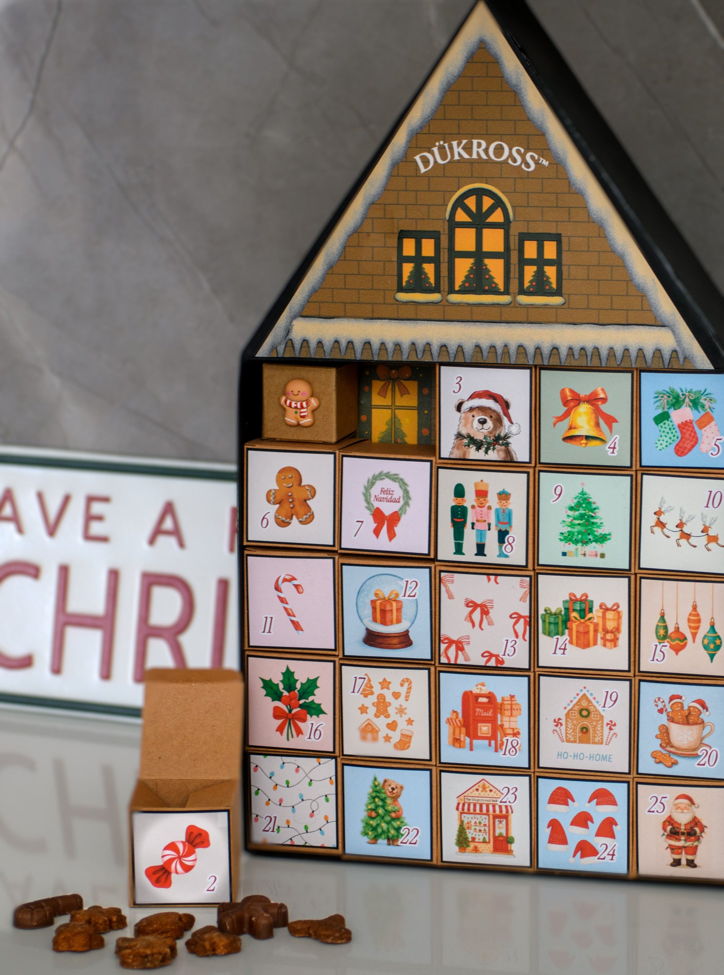 Calendario Adviento Home: Calendario de Adviento con 25 cajitas llenas de galletas y chocolates navideños, presentado en una casita metálica hecha completamente a mano. Una pieza única para vivir la magia día a día.