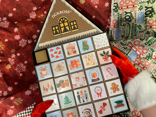 Calendario Adviento Home: Calendario de Adviento con 25 cajitas llenas de galletas y chocolates navideños, presentado en una casita metálica hecha completamente a mano. Una pieza única para vivir la magia día a día.